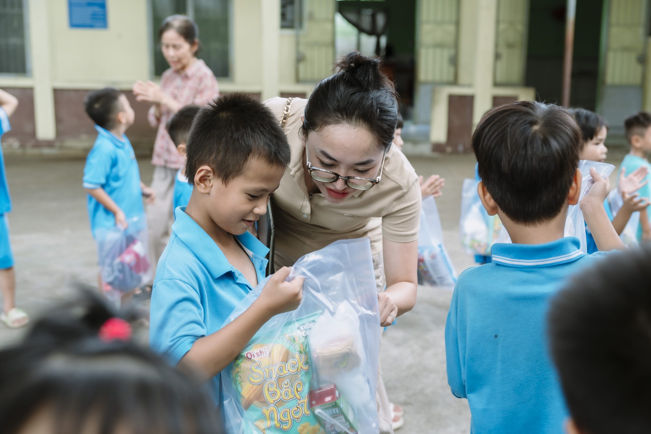 (Cán bộ nhân viên Bình Minh trao quà cho các em học sinh)